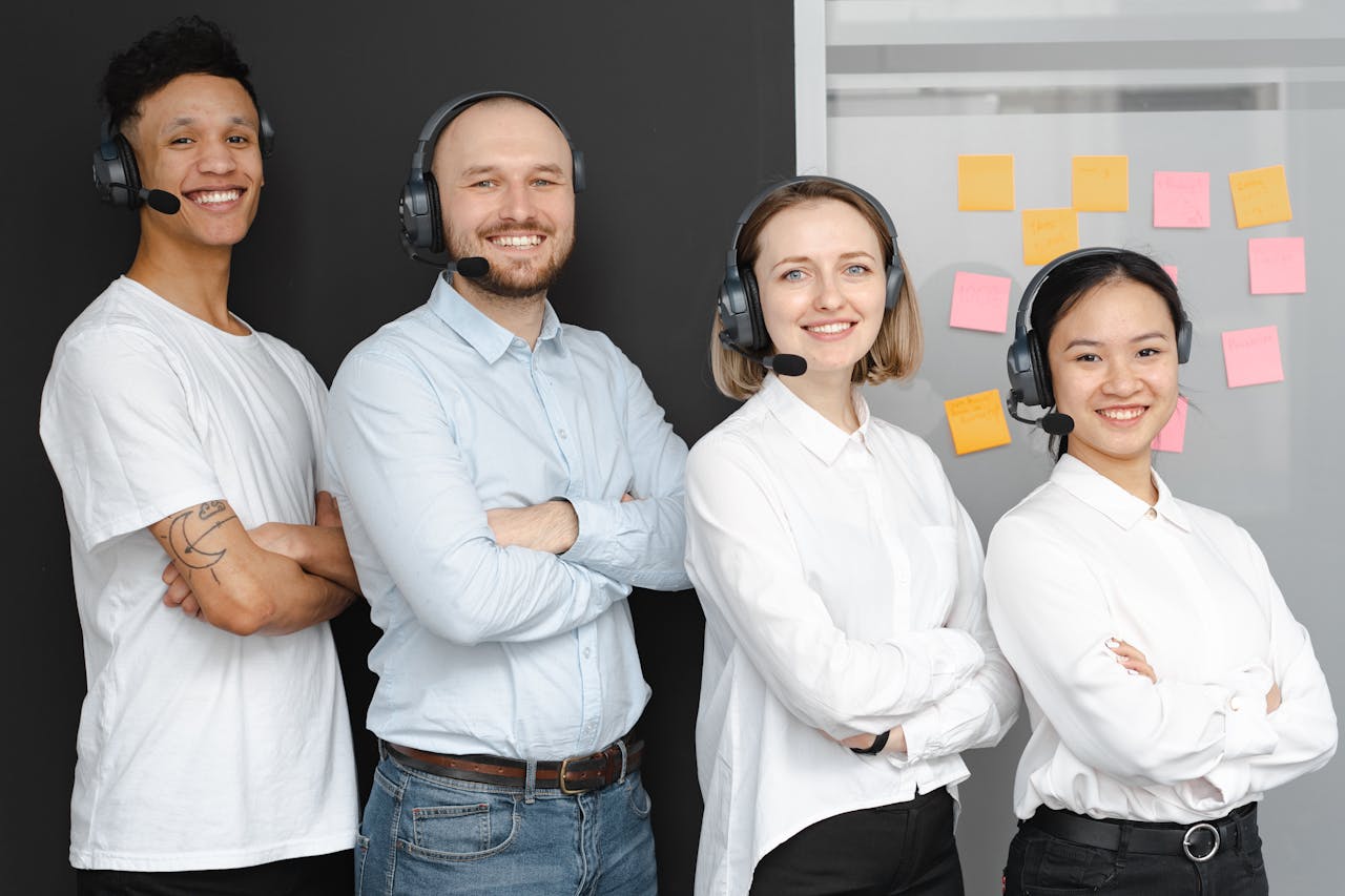 About Team of diverse call center professionals smiling and standing confidently with headsets and microphones.